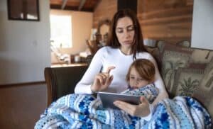Mother filling out pediatric intake forms from the comfort of her own home